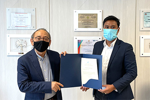 A local staff member presenting a donation certificate to the Bandung Institute of Technology