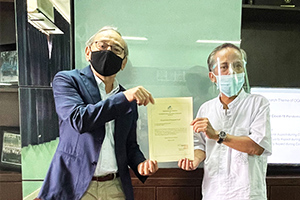 A local staff member presenting a donation certificate to IPB University