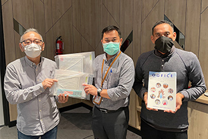 A local staff member presenting a donation certificate to Badak LNG staff members in charge