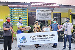 A local staff member presenting donated equipment to an elementary school in the Bontang area