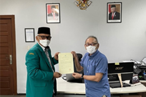 A grant certificate being presented to Vice President Dr. Hajjul Kamil  of Syiah Kuala University