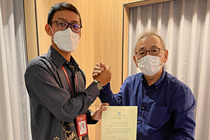 A grant certificate being presented to Mr.Iqbal, a PR officer of PT. BADAK
